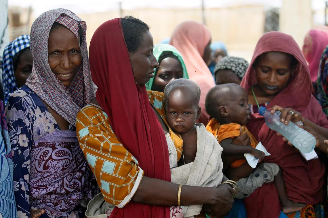 FILE PHOTO: Women wait with their children under a shed for food rations at a internally displaced persons (IDP) camp on the outskirts of Maiduguri, northeast Nigeria June 6, 2017. REUTERS/Akintunde Akinleye/File Photo