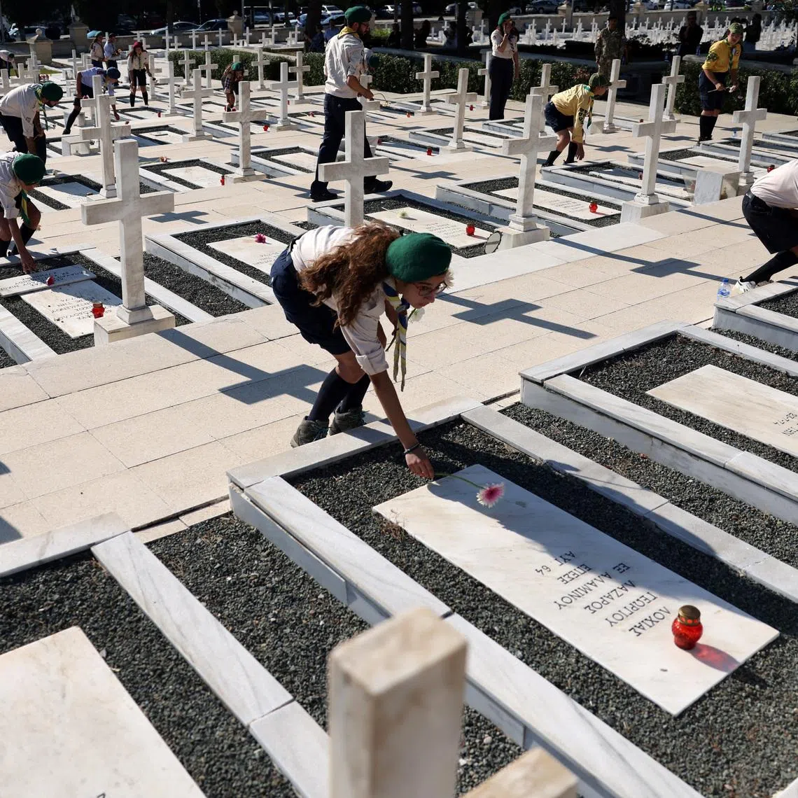 Scouts lay flowers on graves of soldiers killed in the 1974 Turkish invasion of Cyprus, during a memorial service at the Tymvos Macedonitissas military cemetery in Nicosia, Cyprus, July 20, 2026. REUTERS/Yiannis Kourtoglou