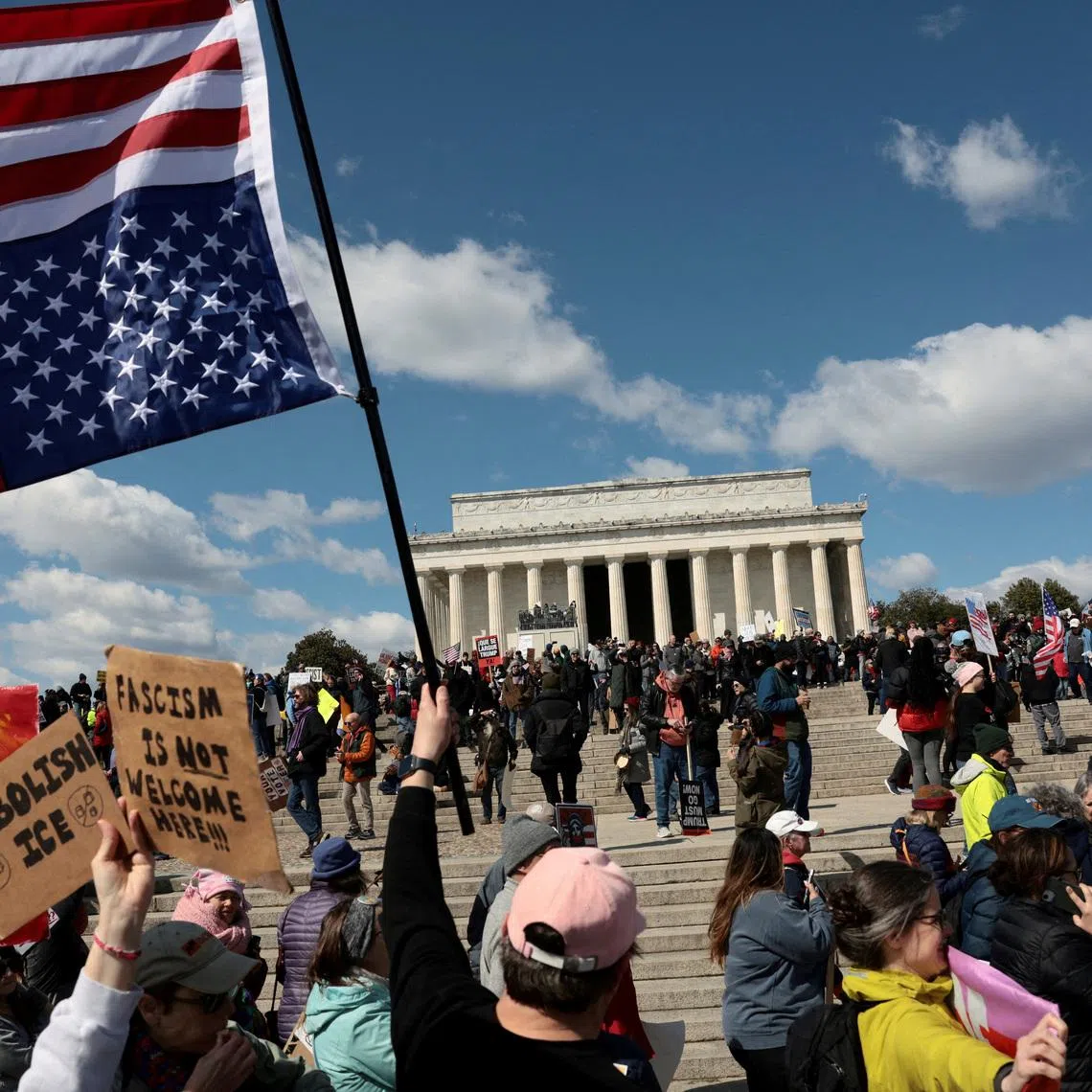 A demonstrator holds an upside-down American flag during a \"No Kings\" protest in front of the Lincoln Memorial, amid nationwide demonstrations against U.S. President Donald Trump's administration policies, in Washington, D.C., U.S., March 28, 2026. REUTERS/Evelyn Hockstein