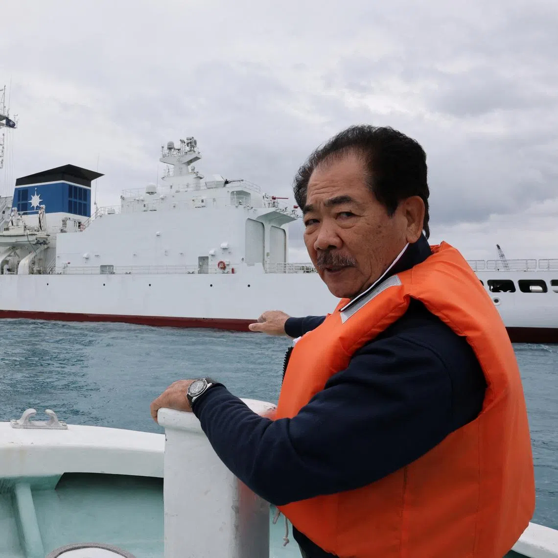 Hitoshi Nakama, a fisherman and local councilor in Ishigaki who has been fishing around a group of disputed islands called Senkaku Islands in Japan, also known in China as Diaoyu Islands, speaks during an interview with Reuters as his fishing boat sails past Japan coast guard ship docked at a port in Ishigaki, Okinawa Prefecture, Japan, January 13, 2026. REUTERS/Kim Kyung-Hoon