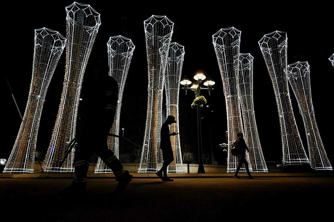 People walking past a Christmas decoration in downtown Caracas, Venezuela on Oct 1, 2025. 