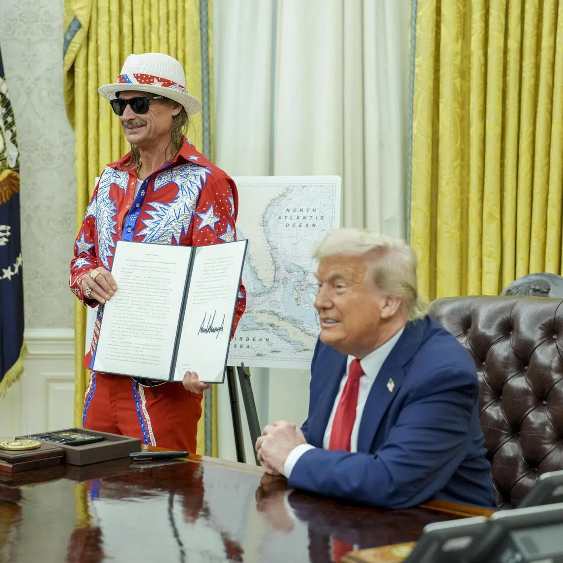 US President Donald Trump, alongside the singer Kid Rock, makes remarks as he signs executive orders in the Oval Office of the White House in March 2025.