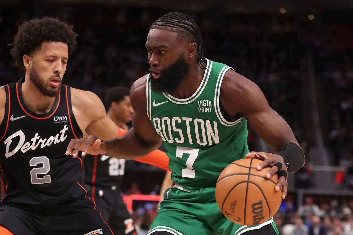 Jaylen Brown of the Boston Celtics drives around Cade Cunningham of the Detroit Pistons during the first half at Little Caesars Arena.