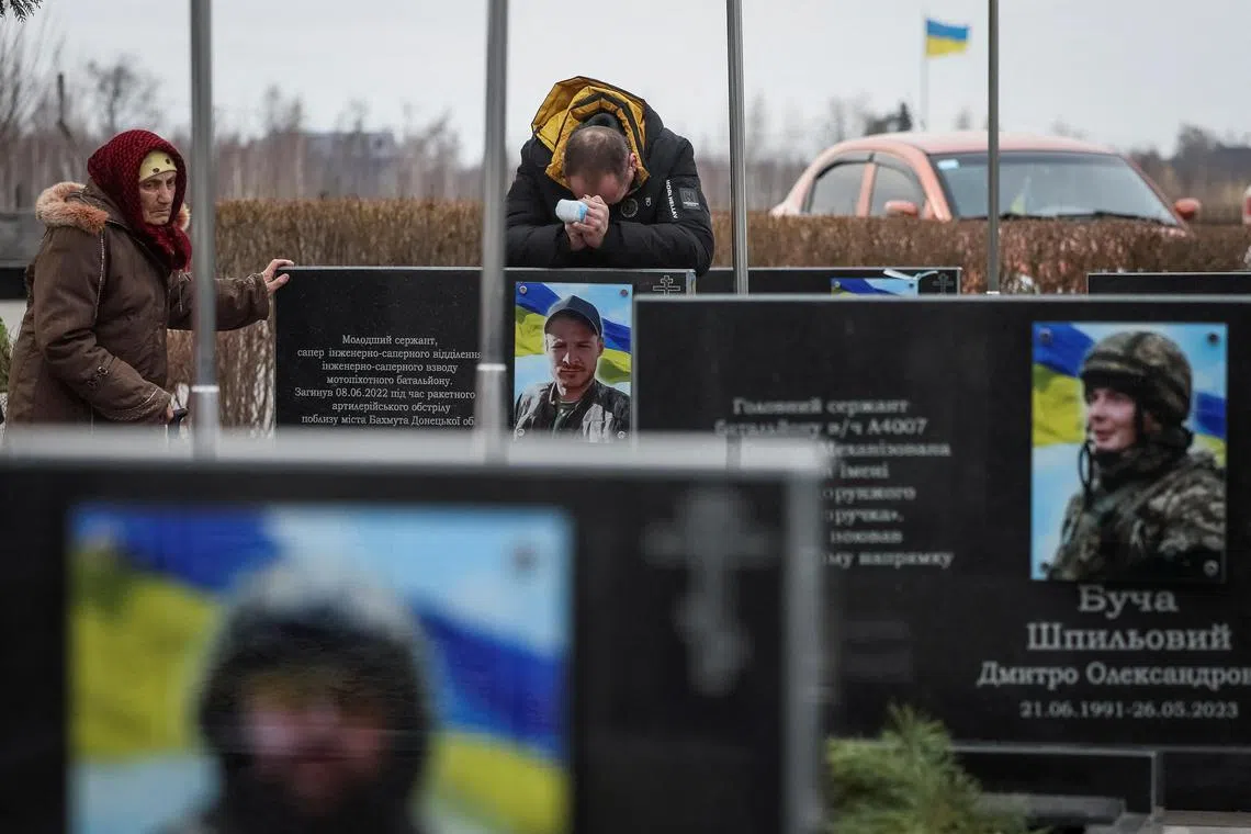 People visit the graves of their relatives, Ukrainian defenders killed in action, on the second anniversary of Russia's invasion of their homeland.