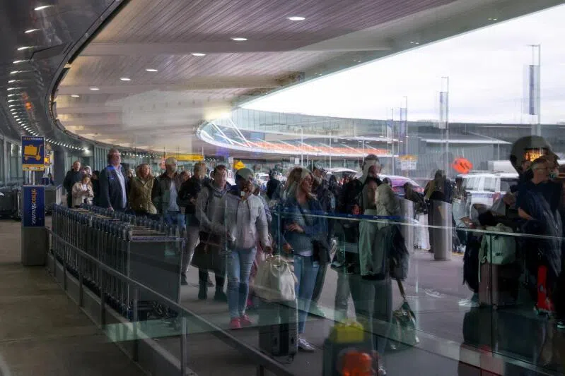 Air travellers reflected in a window wait outside Terminal 8 in TSA security lines at John F. Kennedy International Airport, in Queens, New York City, on March 27, 2026.