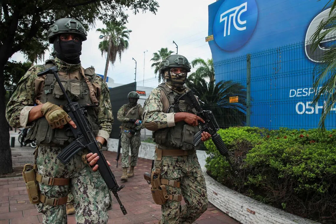 Members of security forces walk outside local TV station TC following Ecuador's President Daniel Noboa's visit a after hooded and armed people took over the studio during a live broadcast, in Guayaquil, Ecuador, January 12, 2024. REUTERS/Henry Romero/File Photo