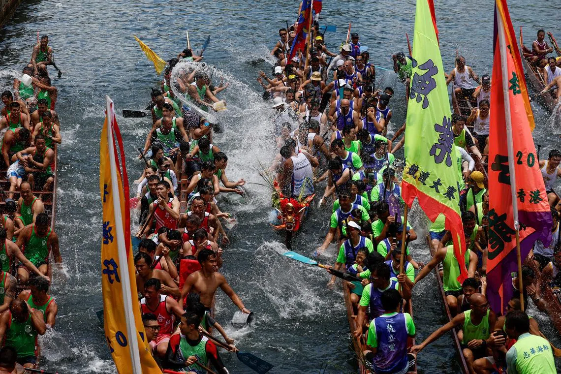 Participants splash water during a ceremony in between races during Dragon Boat Festival at Aberdeen fishing port in Hong Kong.