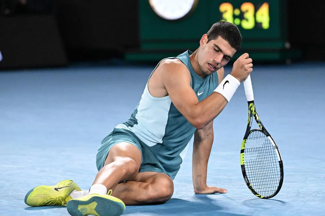 Spain's Carlos Alcaraz falls on the court as he hits a return against Serbia's Novak Djokovic at the Australian Open.