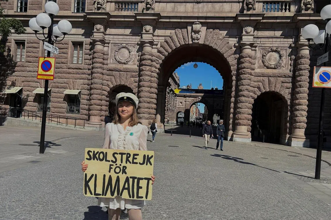 Greta Thunberg stands with a sign that reads, "School Strike for climate", outside the Swedish Parliament on the day of her weekly protest in Stockholm, Sweden, June 9, 2023. REUTERS/Marie Mannes REFILE - QUALITY REPEAT
