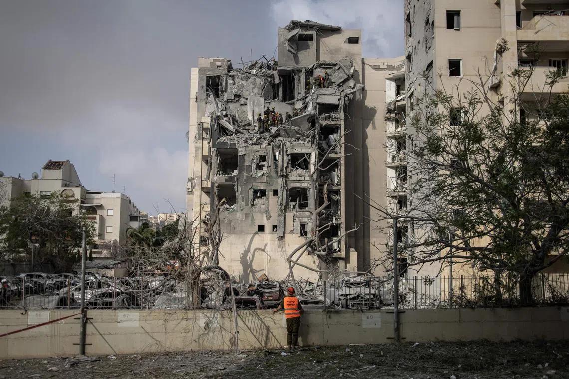 Israeli emergency services and security officers search for casualties in the rubble of a building hit by an Iranian missile in Beersheba in southern Israel on June 24, 2025. US President Donald Trump announced a phased 24-hour ceasefire process beginning at around 0400 GMT on June 24, which Israel said it had agreed to. Iran has not formally accepted a ceasefire. (Photo by John WESSELS / AFP)