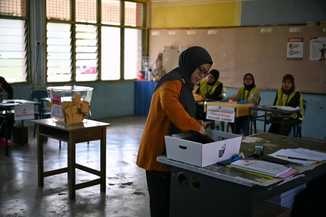 A voter casting a ballot at Tanjung Puteri Primary School in Larkin, Johor, on polling day, July 11.
