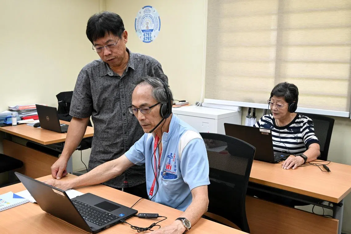 ST20230412_202367239613 Kua Chee Siong/ sfhelp12/
Project director Loh Wee Hiang (left- standing) speaking with  volunteer Mr Thomas Lee (left), with Mdm Dorothy Sim (right) as they man the helpline at the centre in Ang Mo Kio on April 12, 2023. 
