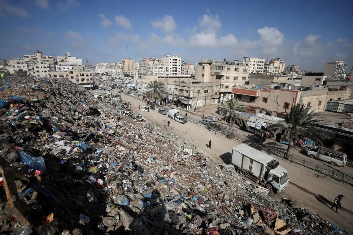 Palestinians walk near a landfill, in Gaza City, February 11, 2026. REUTERS/Dawoud Abu Alkas