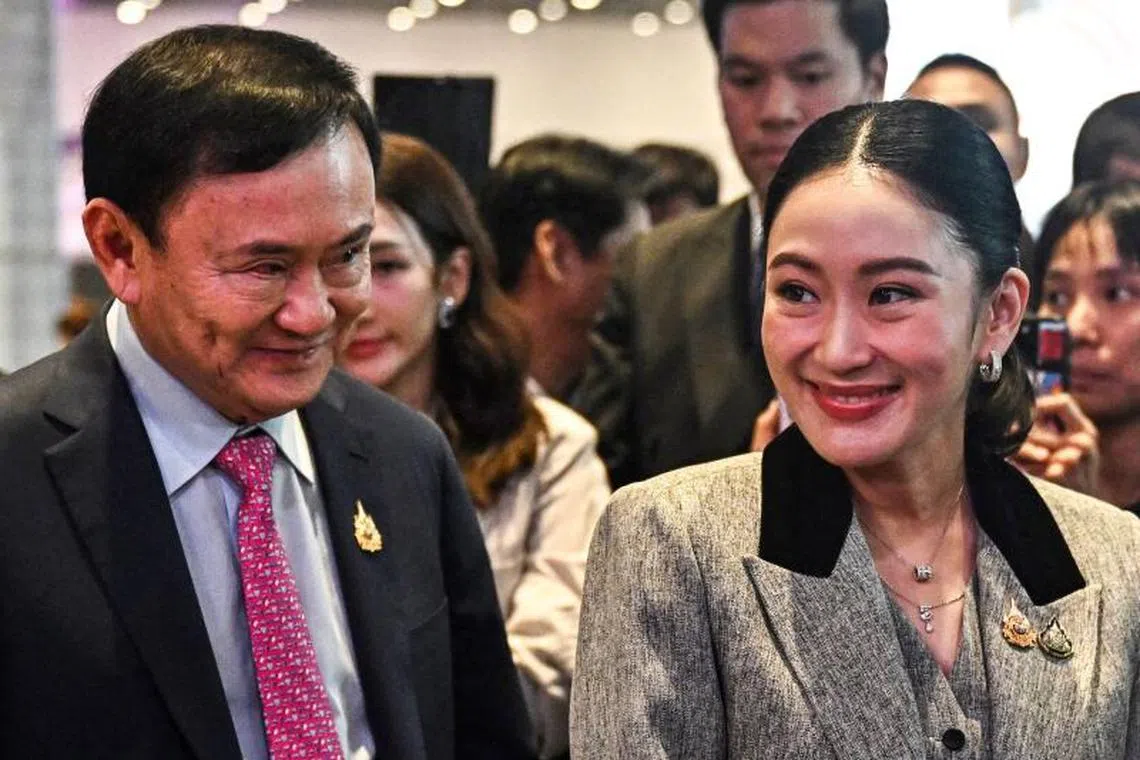 Thailand's suspended Prime Minister and newly-sworn in Culture Minister Paetongtarn Shinawatra (R) walks with her father Thailand's former Prime Minister Thaksin Shinawatra (L) at the SPLASH - Soft Power Forum 2025 at Queen Sirikit National Convention Centre in Bangkok on July 9, 2025. (Photo by Lillian SUWANRUMPHA / AFP)