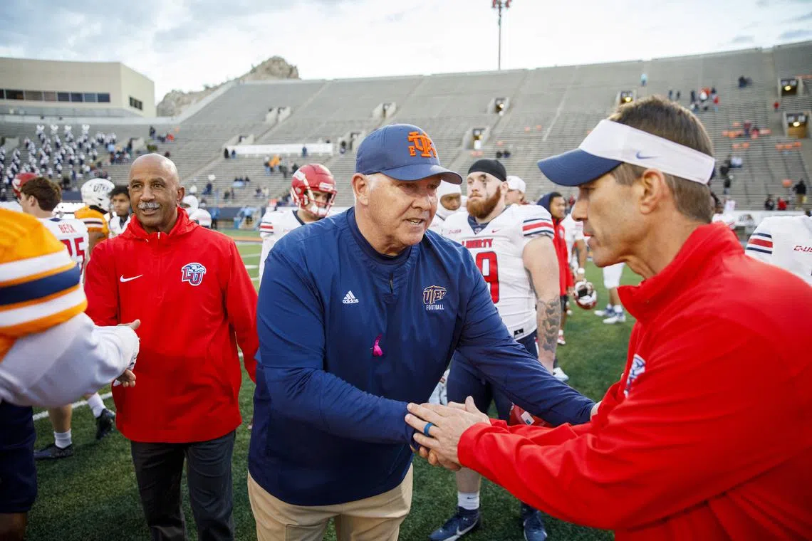 Nov 25, 2023; El Paso, Texas, USA; No. 22 Liberty Flames head coach Jamey Chadwell (right) shakes hands with UTEP Miners head coach Dana Dimel after defeating the Miners at Sun Bowl Stadium. Mandatory Credit: Ivan Pierre Aguirre-USA TODAY Sports/ File Photo