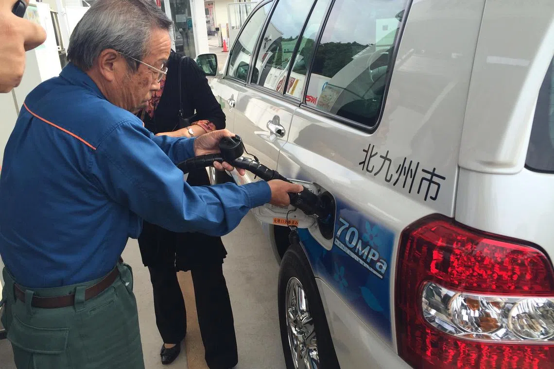 A man pumping in hydrogen into a fuel cell car in Kitakyushu, Fukuoka, Japan.