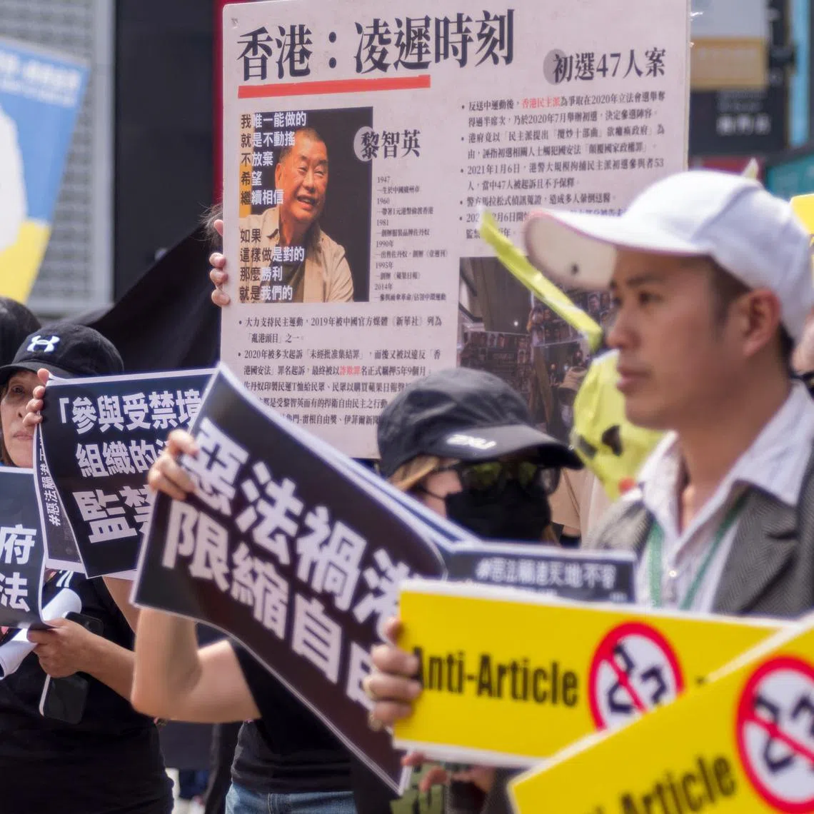 People holding placards and a poster showing Jimmy Lai, protest against the new national security law, in Taipei, on March 23.