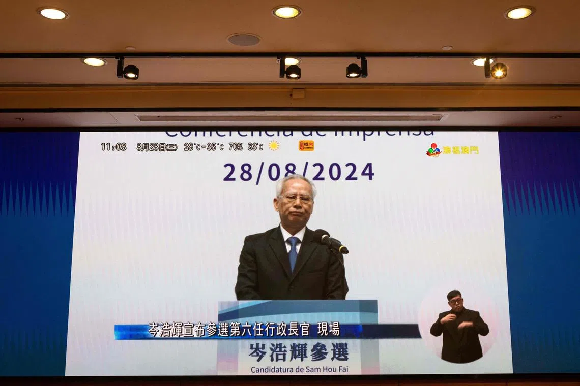 Sam Hou-fai, former chief justice of Macau's court of final appeal, is seen on a screen as he speaks during a presser to announce his bid to run for the Chief Executive position, at the Science Centre in Macau on August 28, 2024. (Photo by Eduardo Leal / AFP)