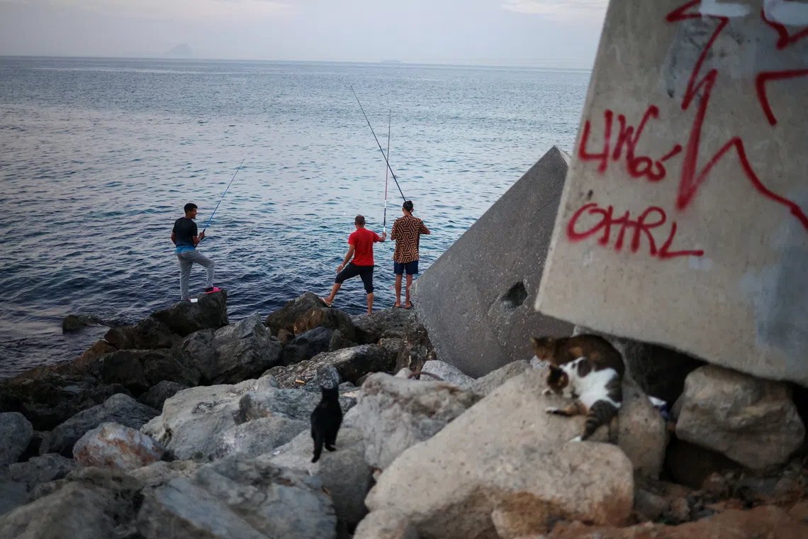 Migrants fish in Trampolin Beach following recent mass crossings of migrants from Morocco to Ceuta, Spain, September 29, 2026. REUTERS/Pedro Nunes