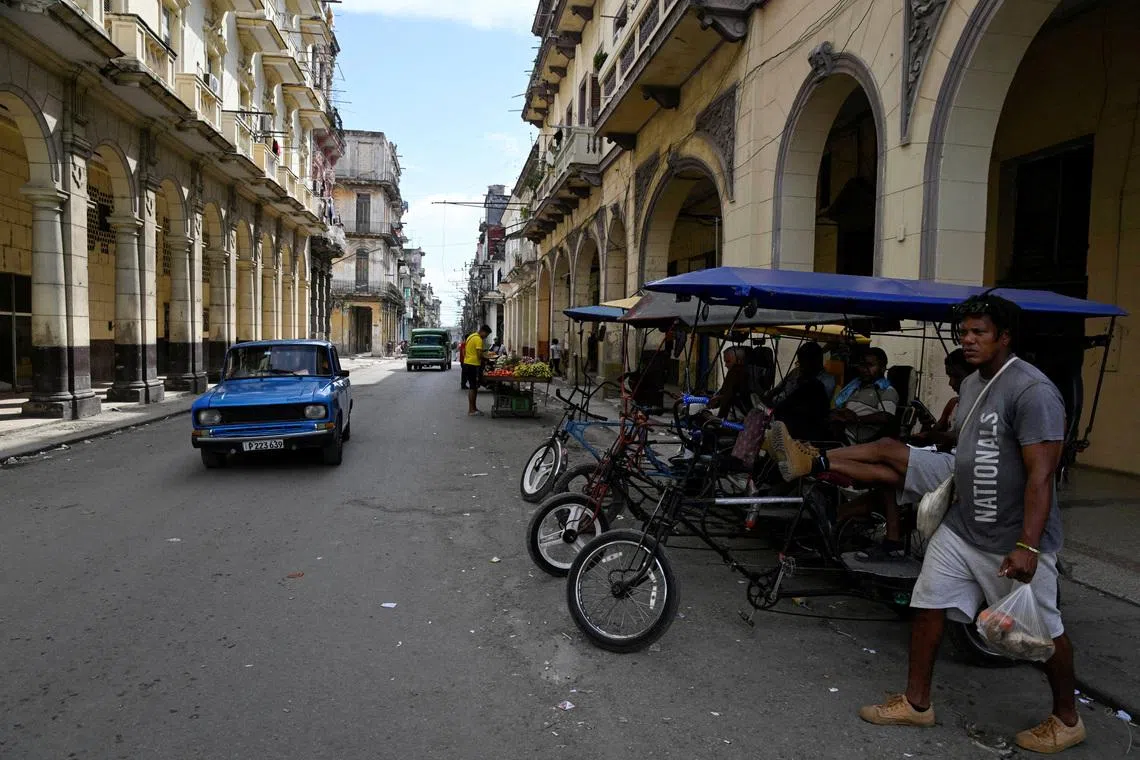 FILE PHOTO: A man walks carrying groceries as U.S.-Cuba tensions rise after U.S. President Donald Trump vowed to stop Venezuelan oil and money from reaching Cuba and suggested the communist-run island to strike a deal with Washington, in Havana, Cuba, January 11, 2026. REUTERS/Norlys Perez/File Photo