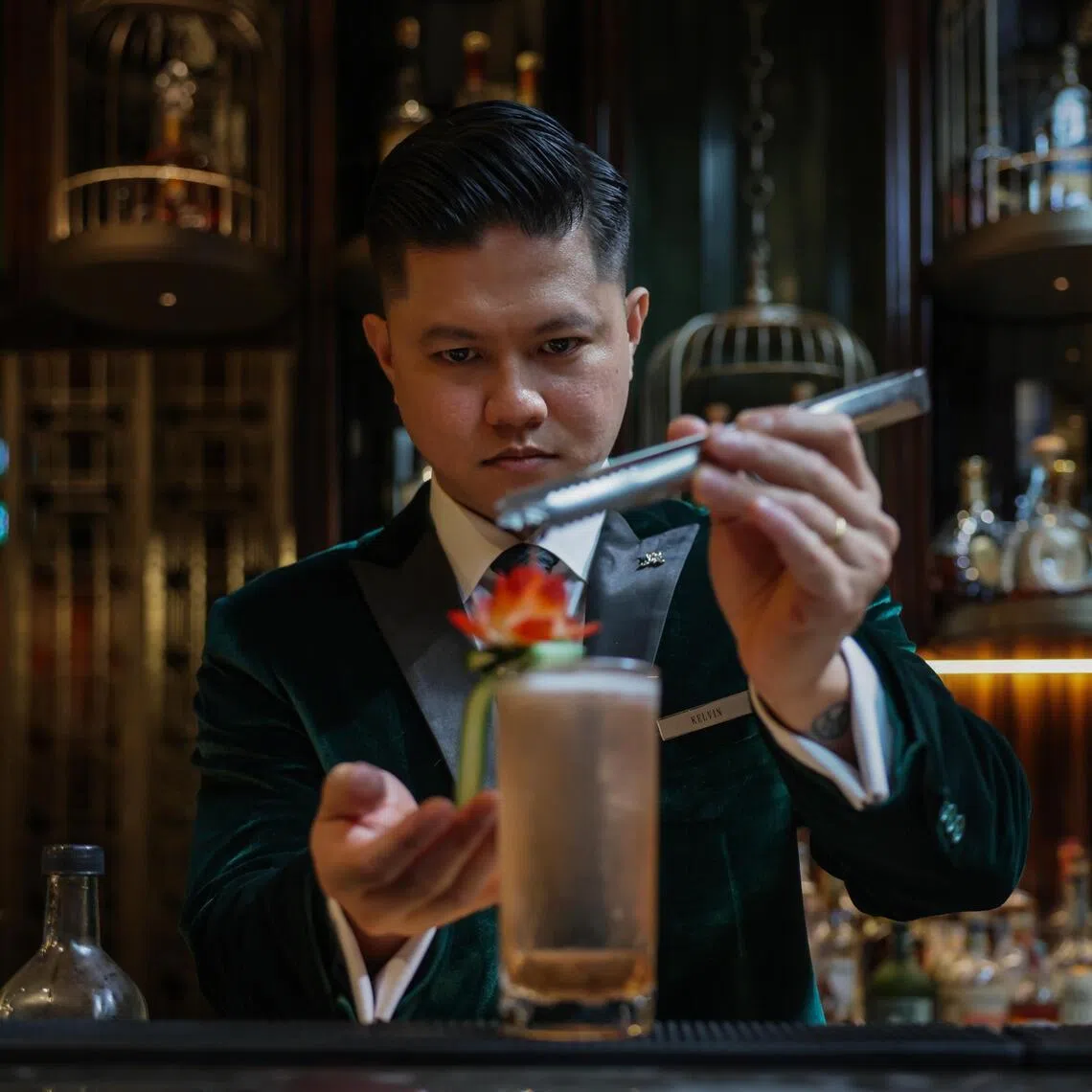 ST20260317_202634400725: Gin Tay/ clzero/ Cherie Lok/
Portraits of Kelvin Saquilayan, 34, Head Bartender at The St. Regis Club, poses with a selection of mocktails (from left): Past Perfect, Time Capsule, and Quantum Leap on Mar 17, 2026.