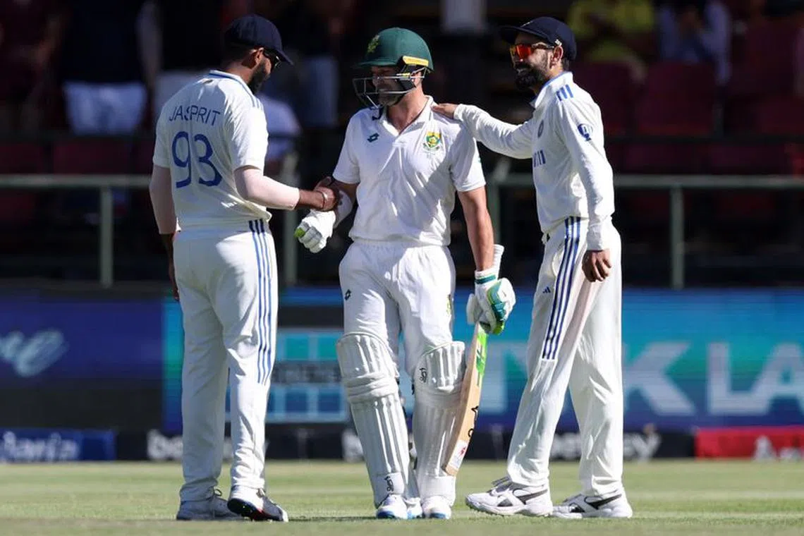 Cricket - Second Test - South Africa v India - Newlands Cricket Ground, Cape Town, South Africa - January 3, 2024 South Africa's Dean Elgar speaks with India's Virat Kohli and Jasprit Bumrah after getting dismissed by Mukesh Kumar and playing his last test innings REUTERS/Esa Alexander