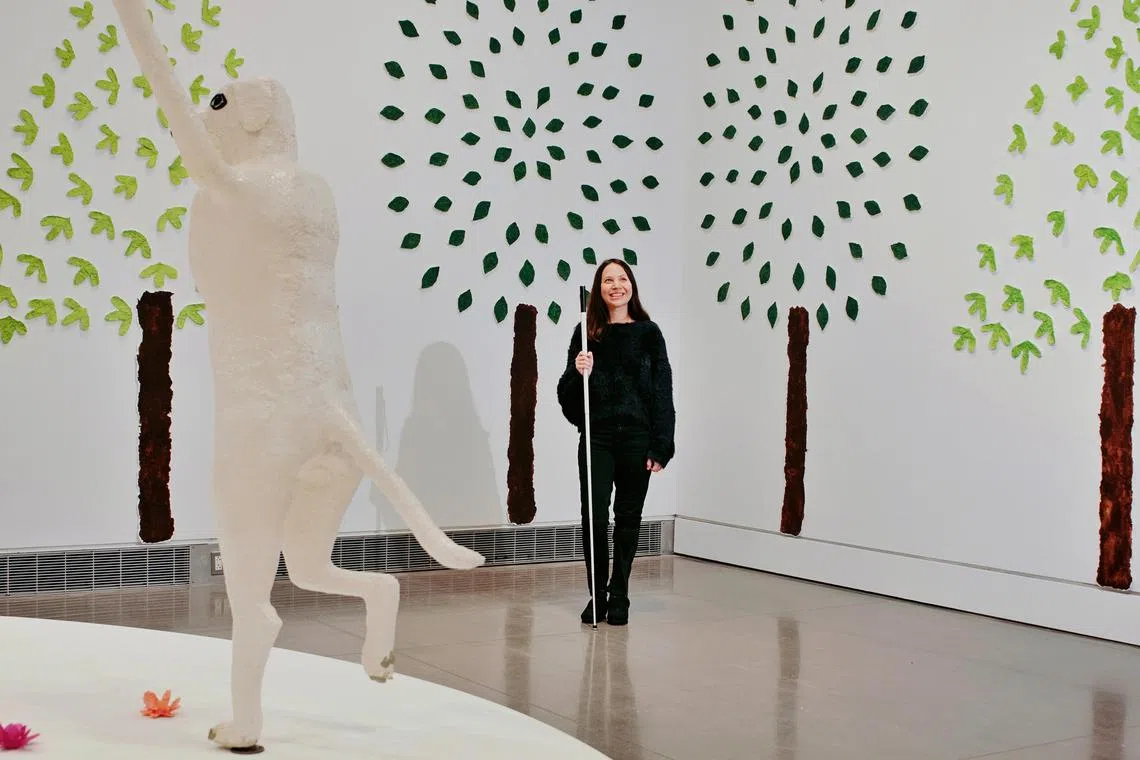 Emilie Gossiaux, an artist who is blind, with White Cane Maypole Dance (2023), an installation featuring papier-mache dog-women dancing, at her first solo museum exhibition in Queens, on Dec 1, 2023. 