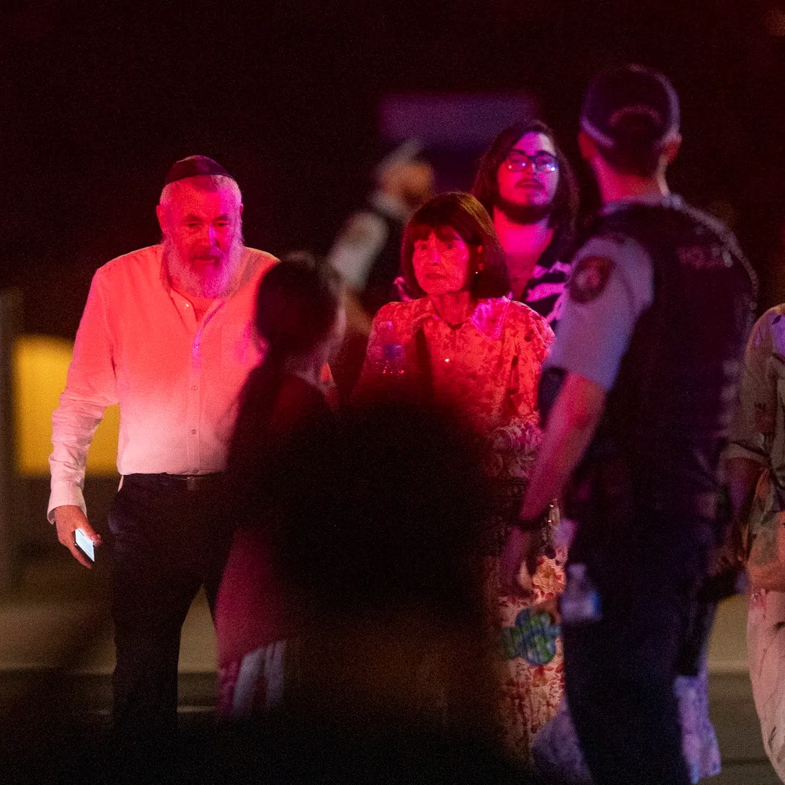 A police officer ushering pedestrians across a street near the scene of the shooting incident on Dec 14.