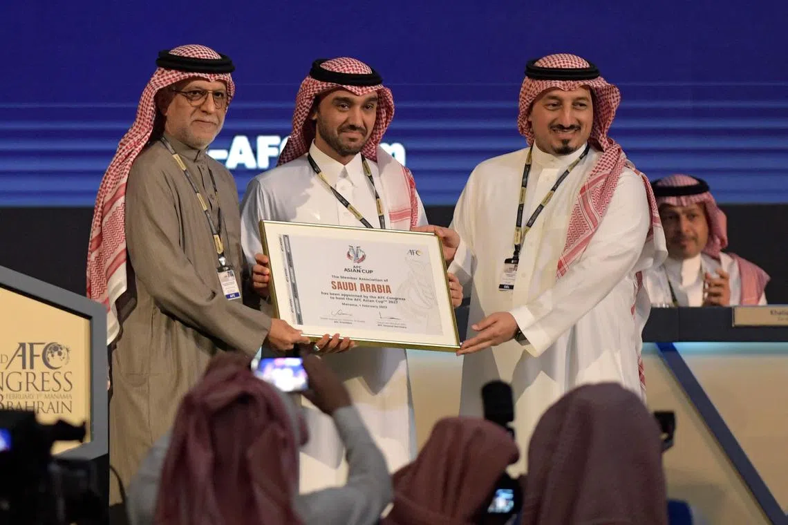 AFC President Salman bin Ibrahim al-Khalifa (left) presents Saudi Arabia's Minister of Sports and Youth Abdulaziz bin Turki al-Faisal al-Saud (centre) with a plaque, appointing Saudi Arabi aas the host of the 2027 AFC Asian Cup.