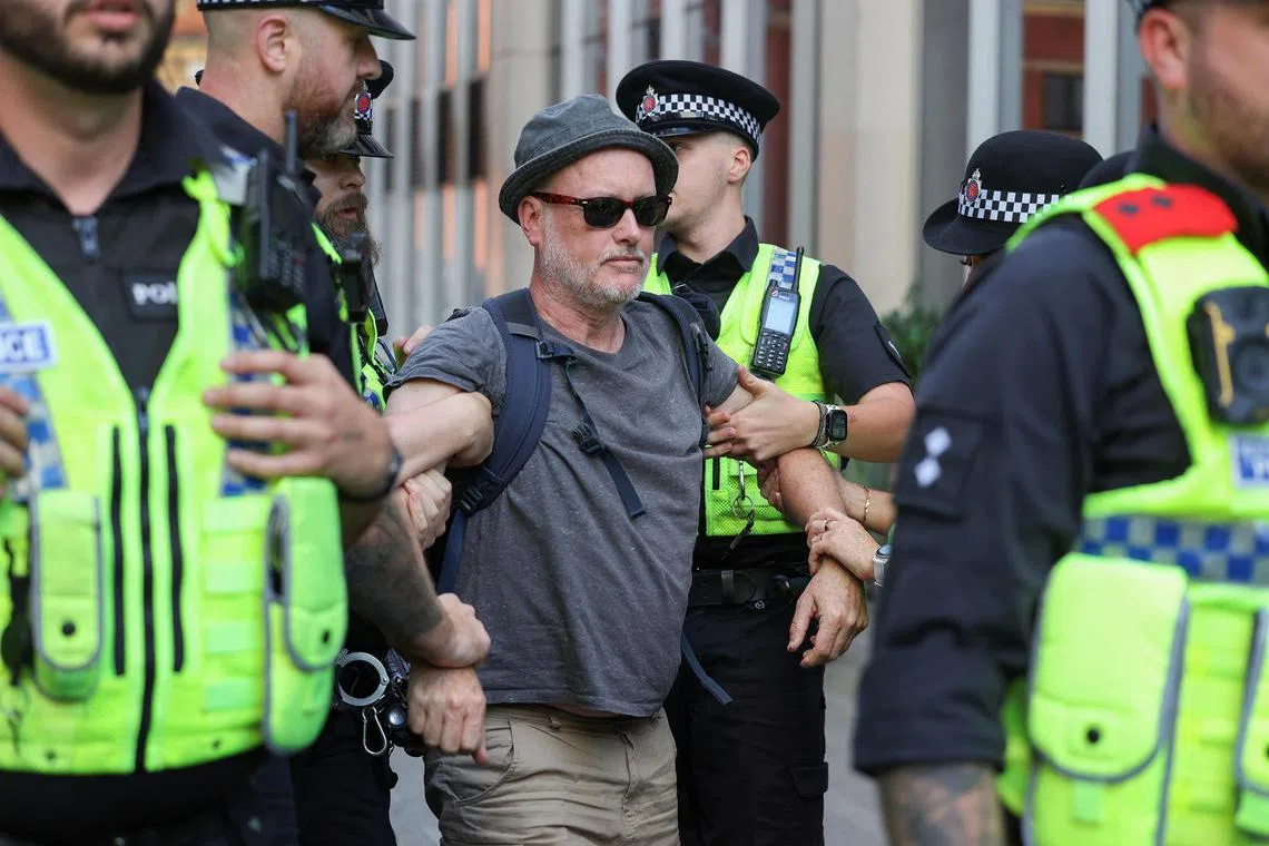 British police detaining a protester at a rally for the banned group Palestine Action in Manchester, on July 12.