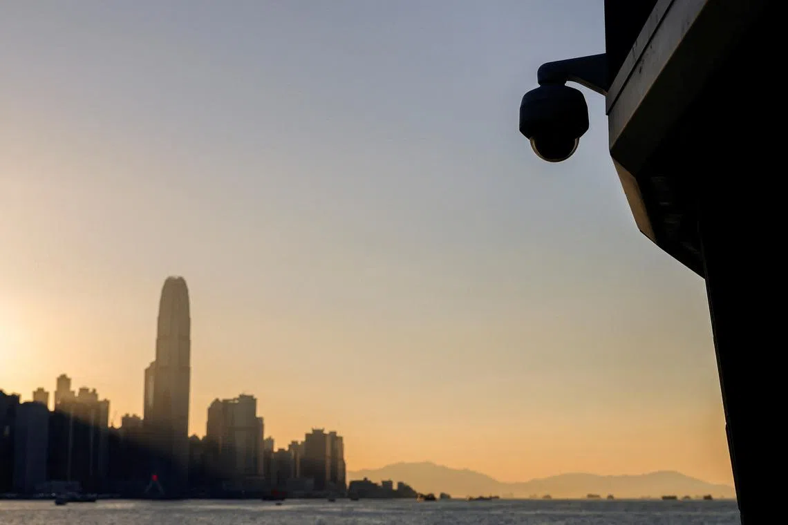 A surveillance camera is seen by the waterfront as skyline buildings stand across Victoria Harbor, in Hong Kong, China October 24, 2023. REUTERS/Tyrone Siu