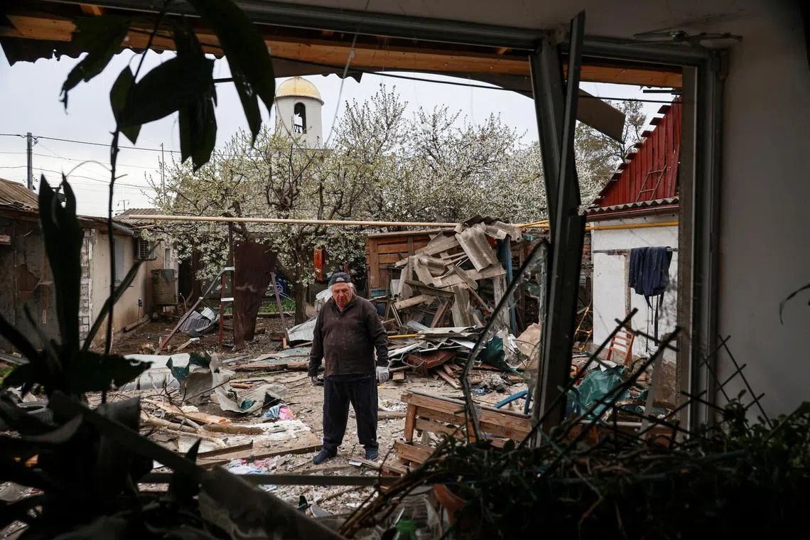 A resident stands on a backyard of his house damaged during a Russian drone strike, amid Russia's attack on Ukraine, in Odesa, Ukraine April 16, 2025. REUTERS/Nina Liashonok