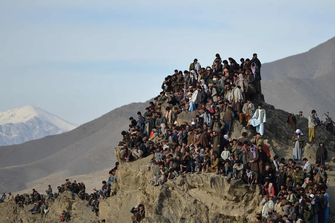 Afghans watching from a hilltop as horsemen compete during 'Buzkashi', a traditional Central Asian sport in the Jurm district of Badakhshan province in Afghanistan on Jan 29, 2026. 