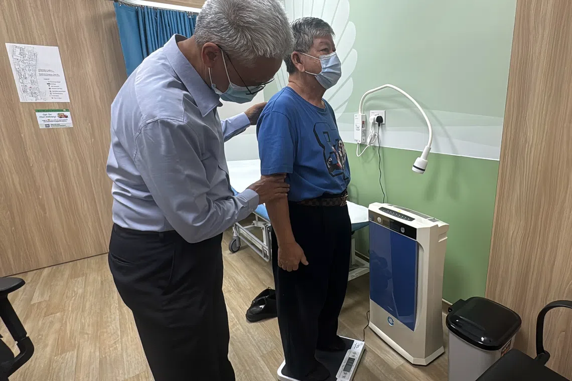 Clinical Associate Professor Tan Ngiap Chuan, director of research and the Primary Care Research Institute under SingHealth Polyclinics, attending to a patient on bone health.