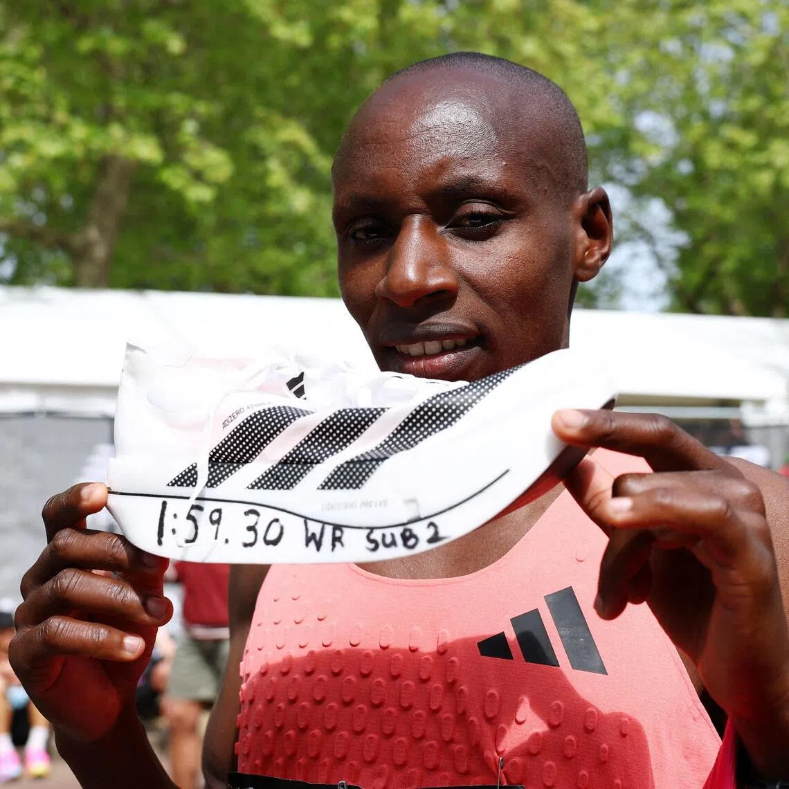Kenya's Sabastian Sawe celebrates with an adidas Adizero Adios Pro Evo 3 shoe after winning the London Marathon and setting a new world record of 01:59:30 on April 26, 2026.