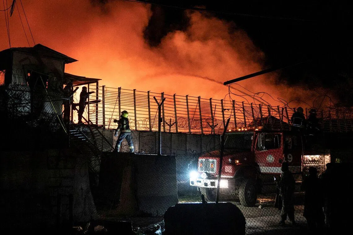 TOPSHOT - Afghan firefighters and Taliban security personnel work to extinguish a fire at the Secondary Rehabilitation Services Centre in Kabul on March 16, 2026. Heavy casualties were feared on March 17 after Afghanistan accused Pakistan of hitting a treatment centre for drug addicts in the capital, Kabul, and killing civilians. Pakistan denied deliberately targeting the facility, instead saying it had conducted precision strikes on "military installations and terrorist support infrastructure". The Pakistani military has struck Kabul several times in recent weeks, as part of a conflict sparked by claims that the Taliban government has harboured extremists who have carried out attacks across the border. (Photo by Wakil KOHSAR / AFP)