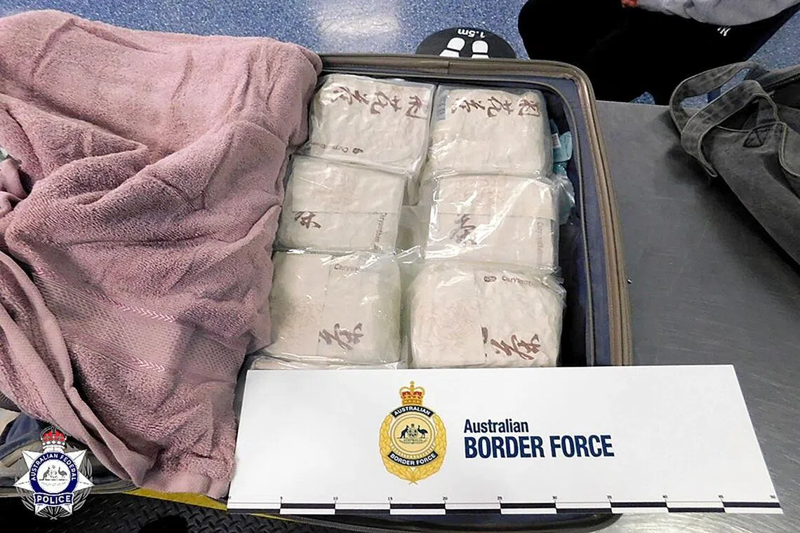 Bags of methamphetamine are seen packed tightly into a suitcase under a pink towel at the Sydney Airport.