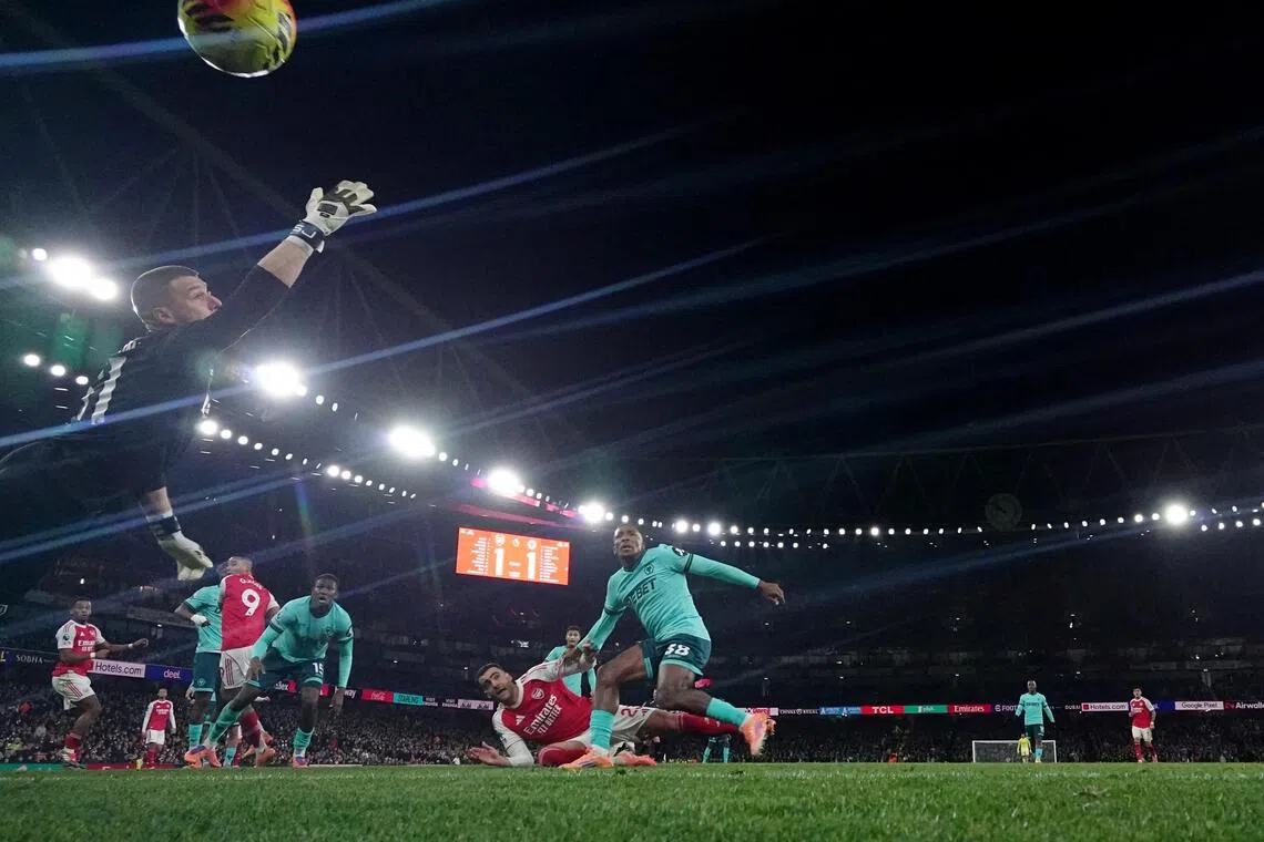 Wolverhampton Wanderers' Yerson Mosquera scores Arsenal's second with an own goal past Wolverhampton Wanderers' Sam Johnstone.
