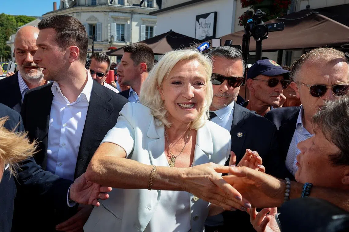 French far-right party Rassemblement National party leader Marine Le Pen (centre) arrives with party president Jordan Bardella (left) for a campaign gathering on July 8.
