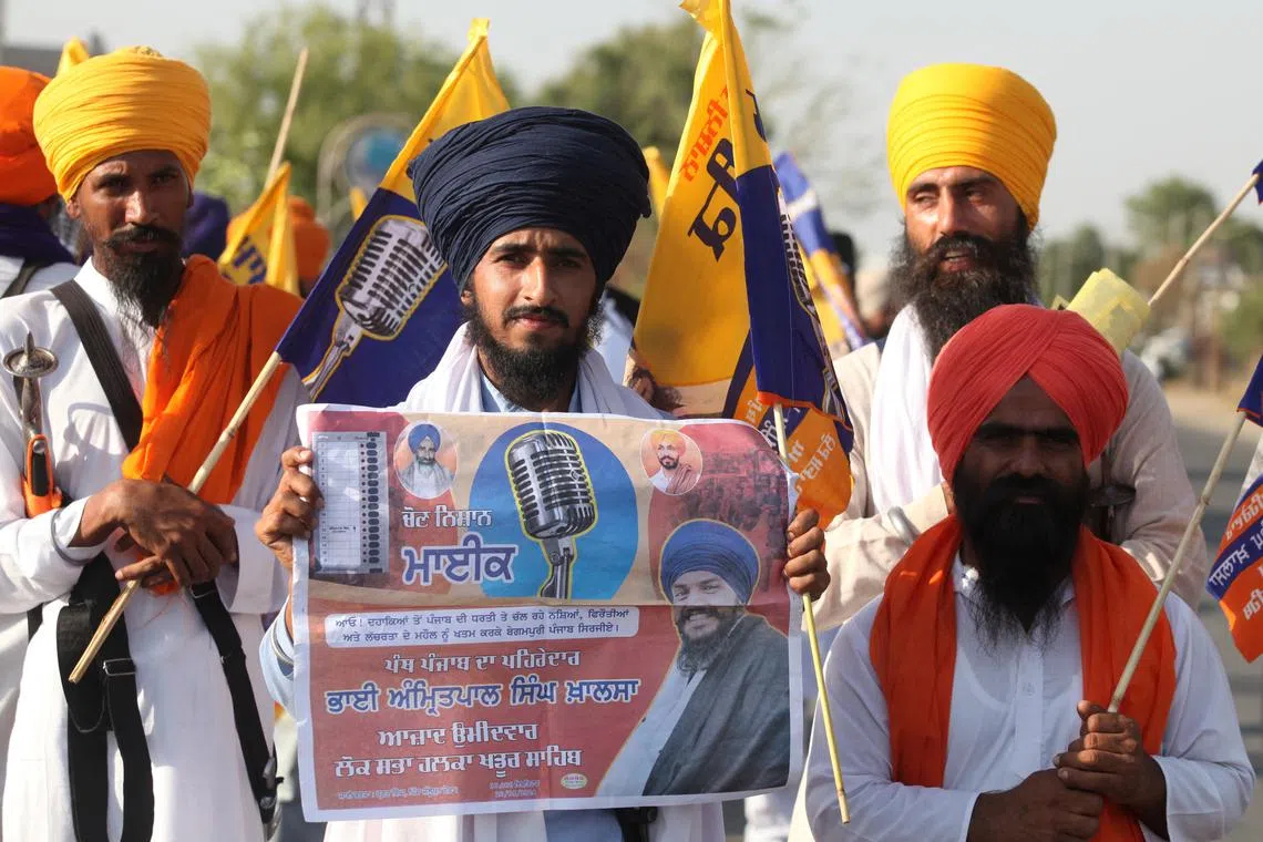 A supporter of Sikh separatist leader Amritpal Singh, an independent candidate from Khadoor Sahib constituency, holds an election campaign poster of Amritpal, in Tarn Taran district, Punjab, India, May 28, 2024. REUTERS/Munish Sharma
