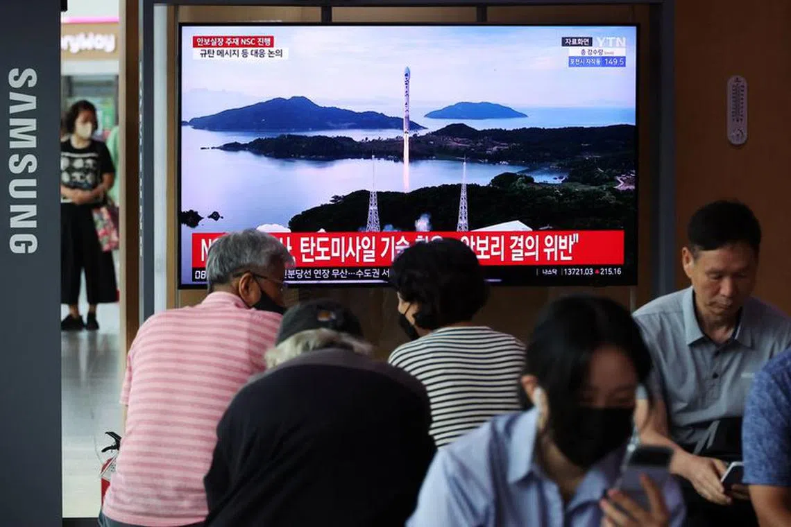 FILE PHOTO: Passengers watch a TV broadcasting a news report on North Korea firing a space rocket, at a railway station in Seoul, South Korea, August 24, 2023. REUTERS/Kim Hong-Ji/File Photo