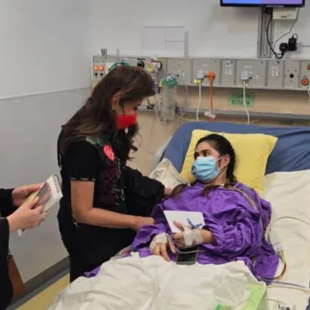 Philippine Senator Imee Marcos is seen in this handout photo visiting domestic helper Rhodora Alcaraz at a hospital in Hong Kong.
