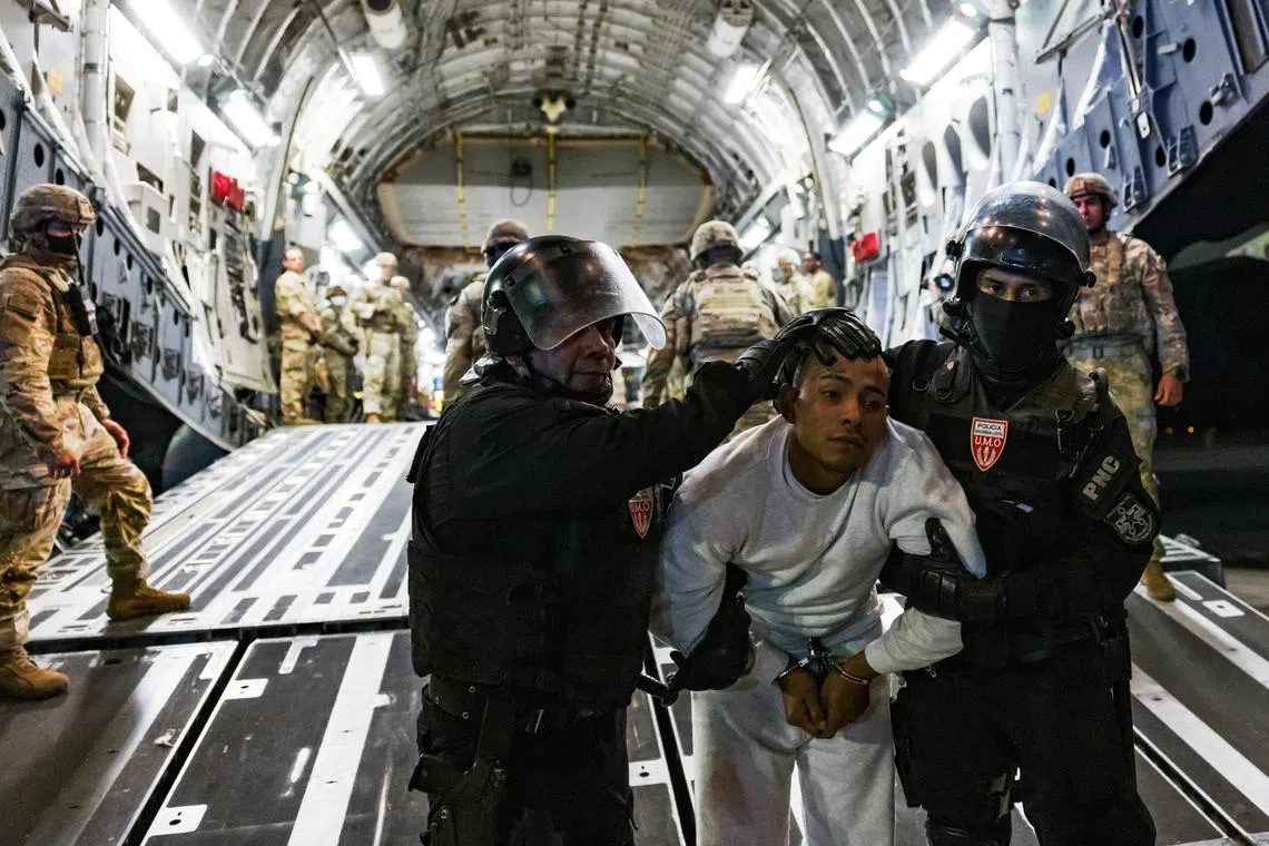 Salvadoran police officers escort an alleged gang member who was deported by the U.S. along with others the U.S. alleges are members of the Venezuelan gang Tren de Aragua and the MS-13 gang to be imprisoned in the Terrorism Confinement Center (CECOT) prison, at the El Salvador International Airport in San Luis Talpa, El Salvador April 12, 2025. Secretaria de Prensa de la Presidencia/Handout via REUTERS/File Photo