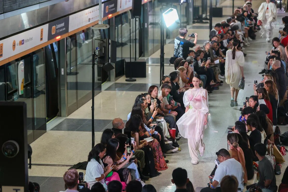 Models walking down a runway set up along the platform of the upcoming Circle Line Cantonment MRT station during the LASALLE College of the Arts’ graduate fashion show DE:CENTERING on May 14. 