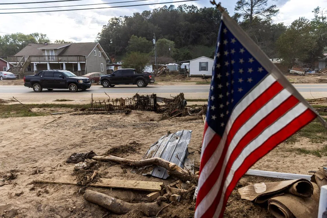 FILE PHOTO: Cars drive along a road affected by floods following the passing of Hurricane Helene in Old Fort, North Carolina, U.S., October 4, 2024.  REUTERS/Eduardo Munoz/File Photo