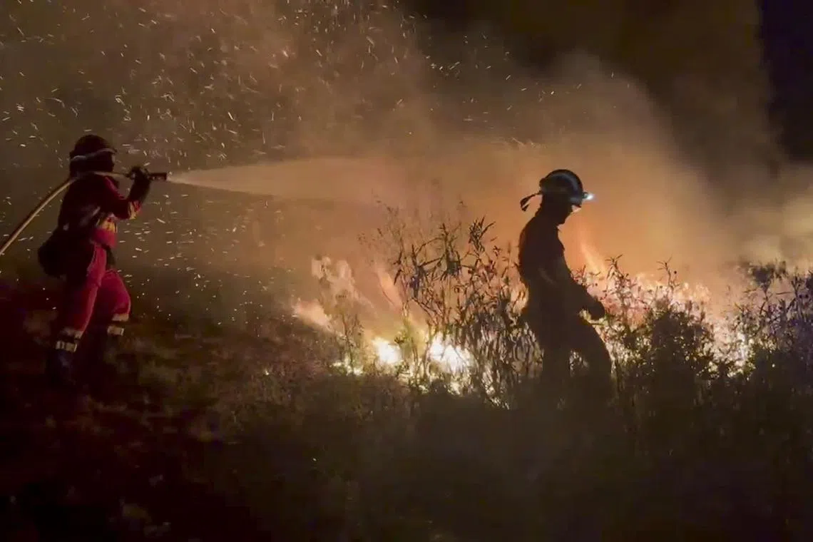 Firefighters tackling a wildfire – fuelled by scorching temperatures – in north-western Spain on Aug 11.