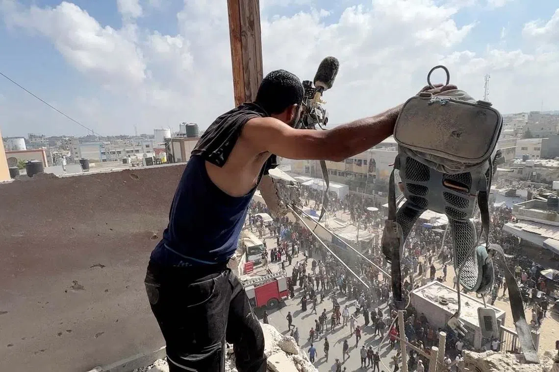 A man holding the equipment used by Palestinian cameraman Hussam al-Masri, who was a contractor for Reuters, at the site where he was killed along with other journalists in Israeli strikes on Nasser hospital in Khan Younis, in the southern Gaza Strip, Aug 25, 2025. 