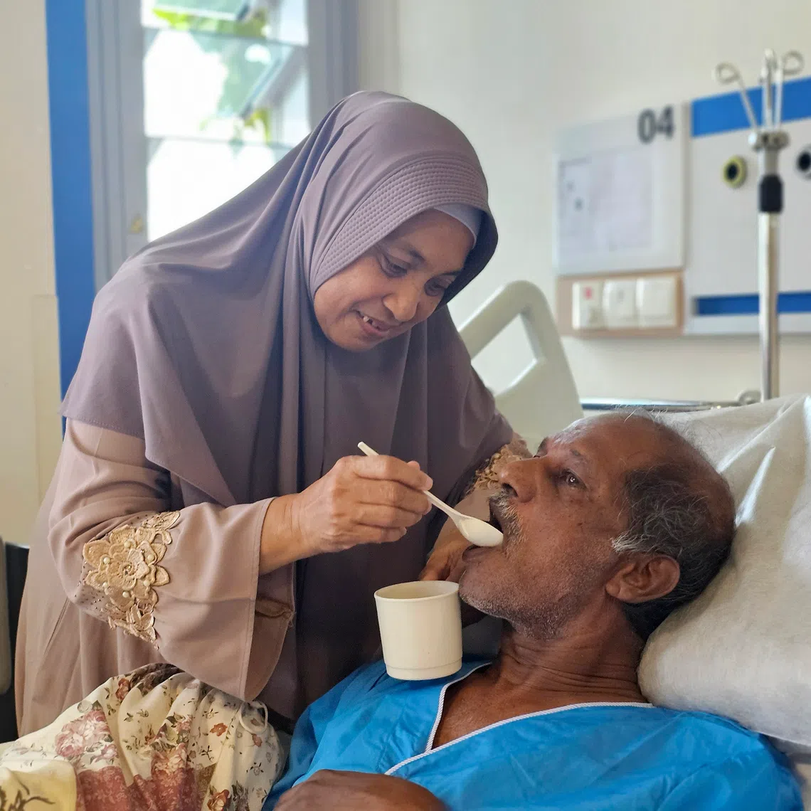 Madam Ismiati Yahya (left) feeding her husband Abdul Hassan Mohamed Yusof (right) at Jurong Community Hospital.