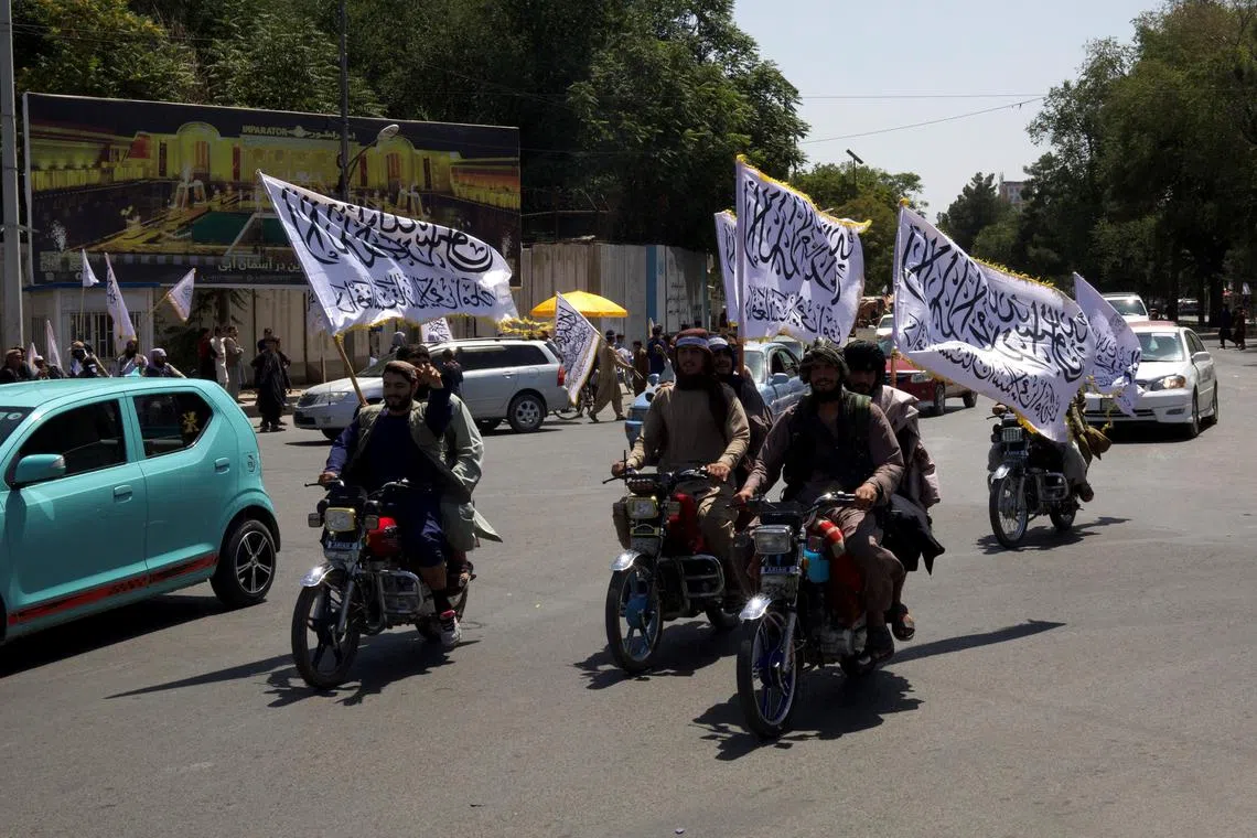 FILE PHOTO: Members of the Taliban carrying flags ride motorbikes as they participate in a rally to mark the third anniversary of the fall of Kabul, in Kabul, Afghanistan, August 14, 2024. REUTERS/Sayed Hassib/File Photo