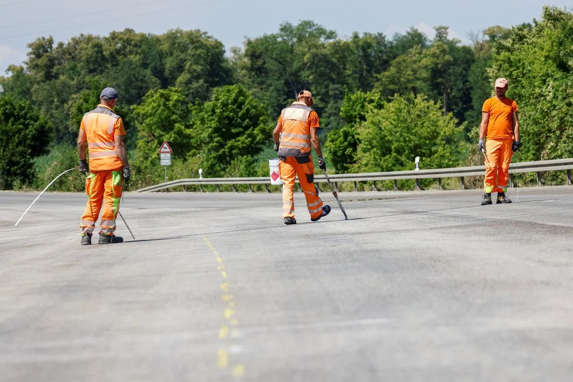 Construction workers mark the road near Germering, Germany July 1, 2025. REUTERS/Michaela Stache